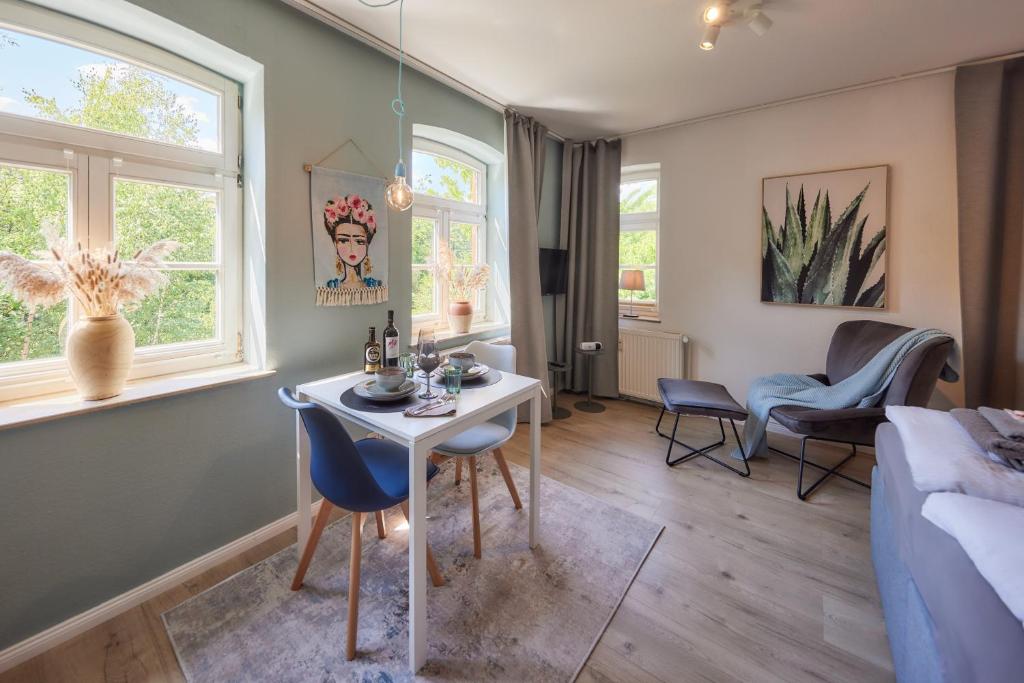 uma sala de estar com uma mesa e cadeiras e um sofá em Kvartier2 in TOP-Lage, 5 min zur Bali-Therme und GOP, HDZ, Arbeitsplatz, Boxspringbett em Bad Oeynhausen