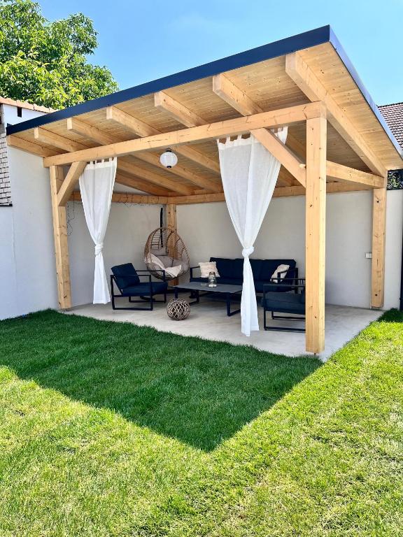 drewniana pergola z dwoma niebieskimi kanapami na patio w obiekcie Ubytování Na Jarošce w mieście Hodonín