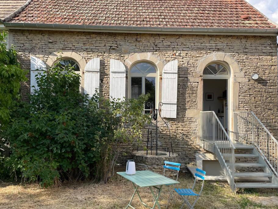 a brick house with a table and chairs in front of it at Ecole des hautes cotes in Fussey
