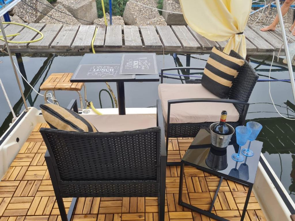 a table and chairs on a deck on a boat at LUPA - La flotta di Willy Giò in Alghero