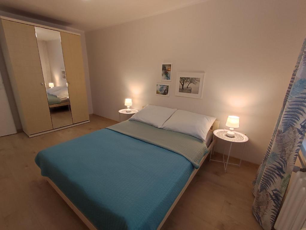 a bedroom with a bed with two tables and a mirror at Apartament Natura in Mrągowo