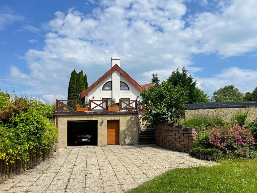 a white church with a cross on top of a driveway at Spacious 3 bedroom house with heated pool in Szigliget