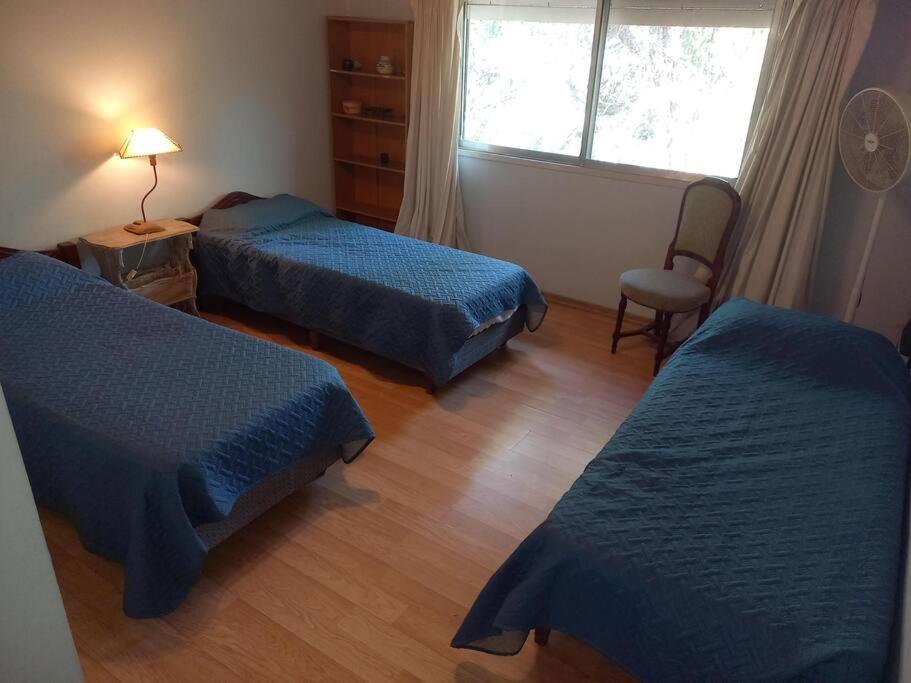 a hotel room with two beds and a window at Casa amplia - Pileta y parque in Bella Vista