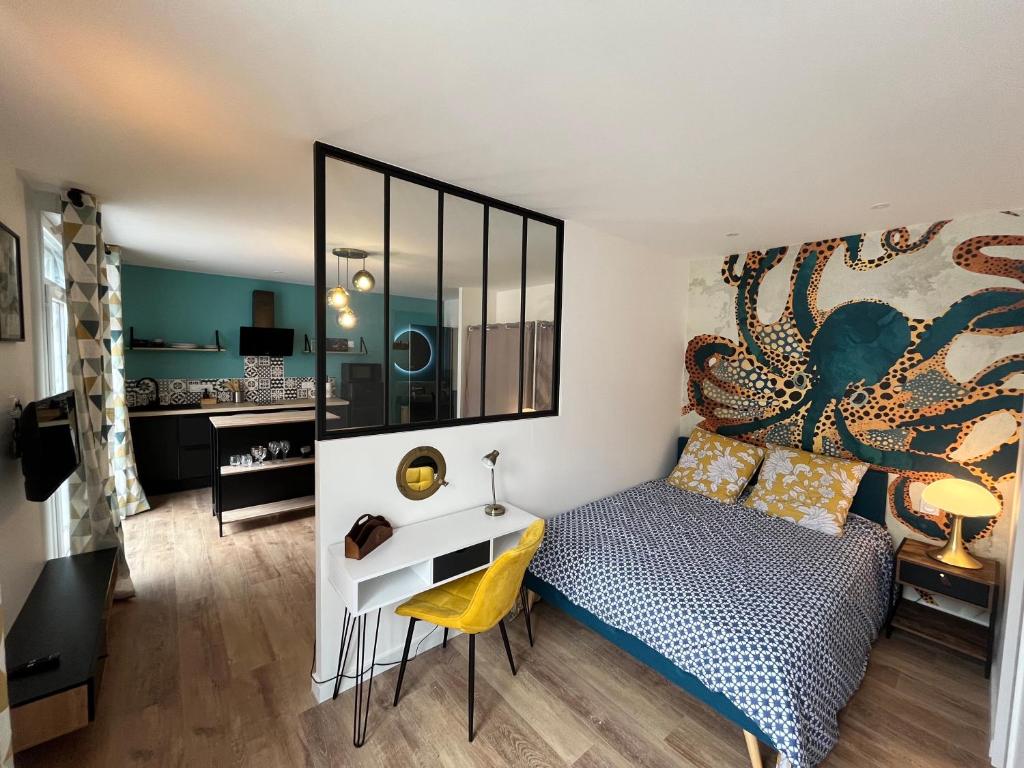een slaapkamer met een bed en een bureau bij STUDIO JULES VERNE - HYPER CENTRE LORIENT in Lorient
