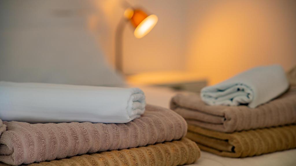 a pile of towels sitting on a table with a lamp at Apartments Edera in Tivat