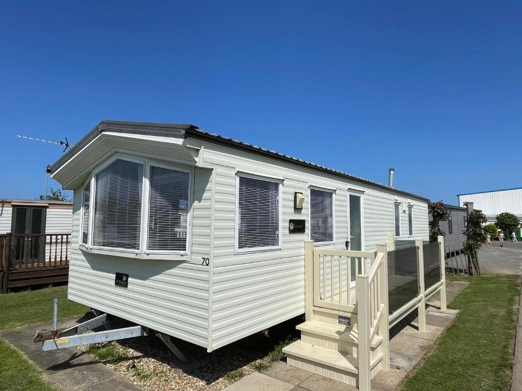biała przyczepa kempingowa z gankiem i domem w obiekcie Golden Palm Resort - Carnival - Coastal Caravan Breaks w mieście Chapel St Leonards