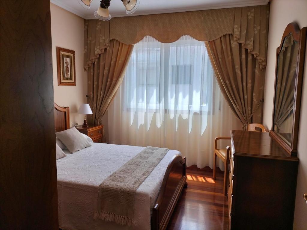 a bedroom with a bed and a large window at O NOSO FOGAR in Melide