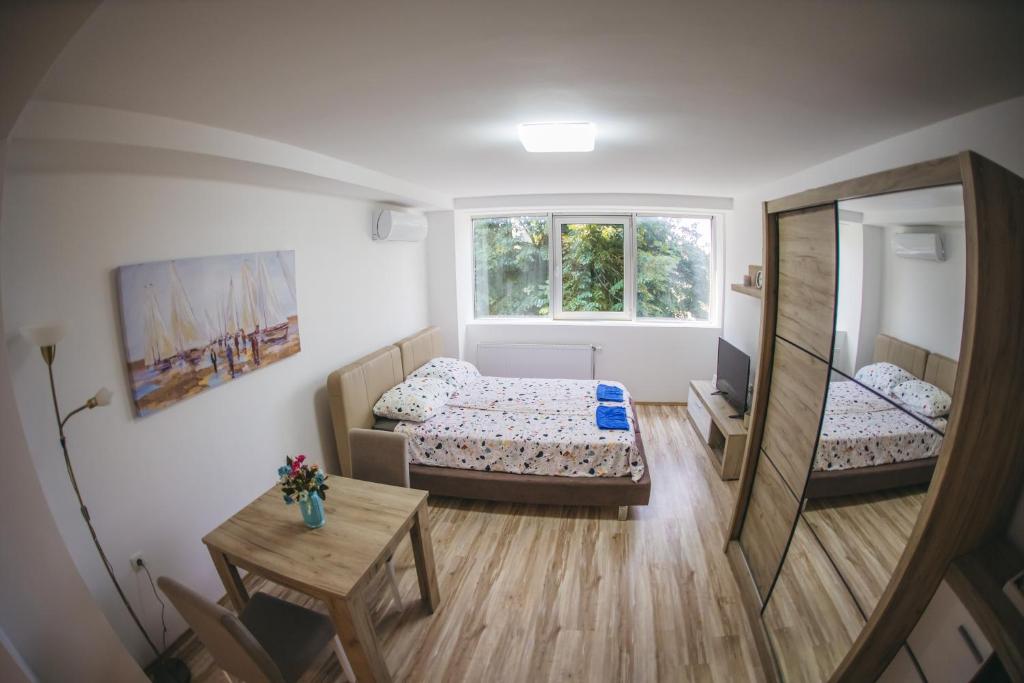 Habitación pequeña con 2 camas y mesa. en RIVERVIEW, en Niš