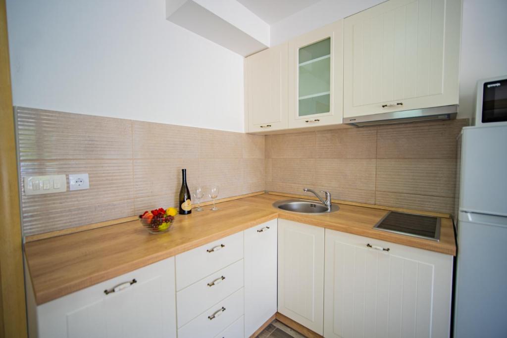 a kitchen with white cabinets and a sink at Apartments Edera in Tivat
