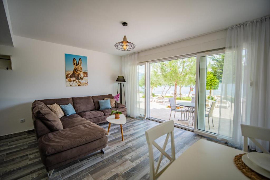 a living room with a couch and a sliding glass door at Apartments Edera in Tivat