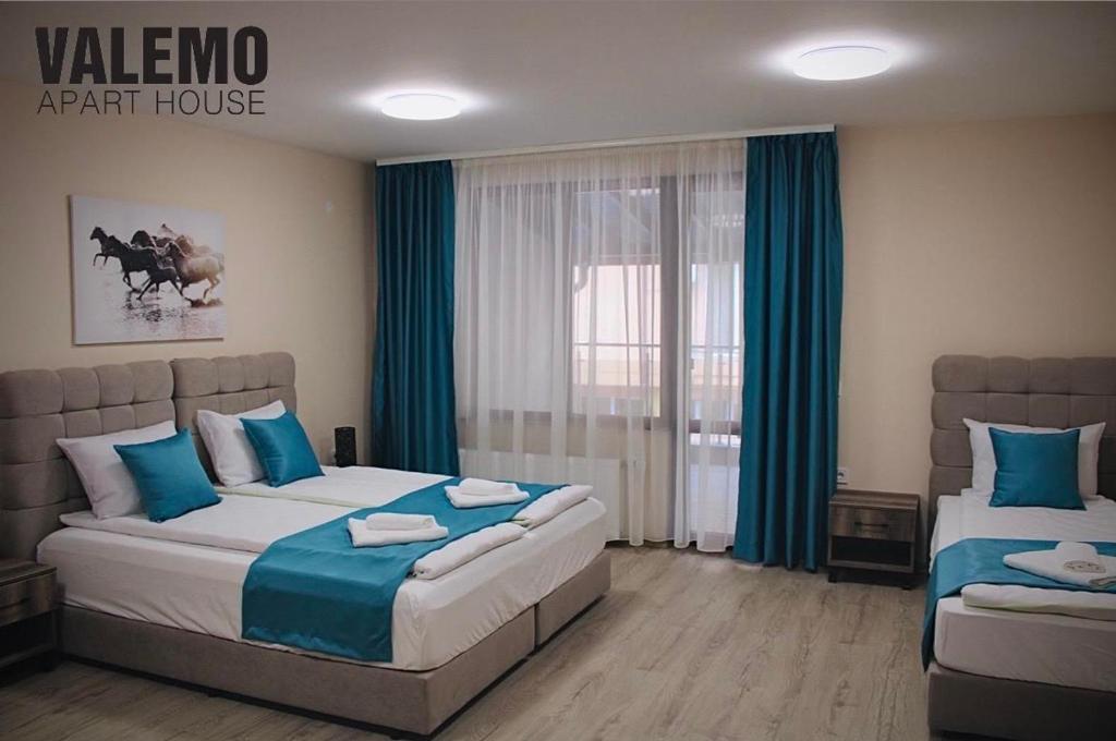 um quarto com 2 camas com lençóis azuis e brancos em VALEMO Apart House em Devin