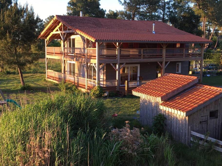 une grande maison en bois avec un toit dans l'établissement La Maison de l'Aérogrange, à Biscarrosse