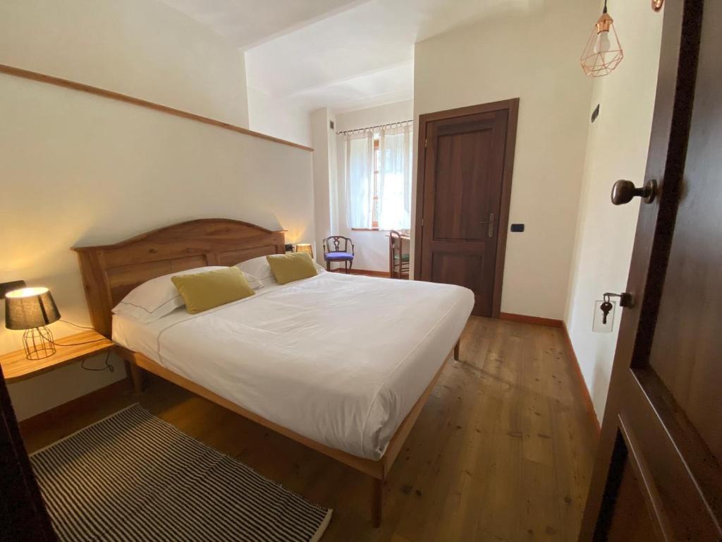 a bedroom with a bed with white sheets and yellow pillows at Mulino del Casale - nature b&b in San Paolo Solbrito