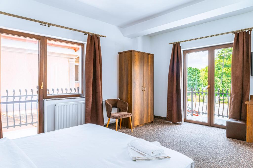 um quarto de hotel com uma cama e uma varanda em Vila Venus em Sânmartin