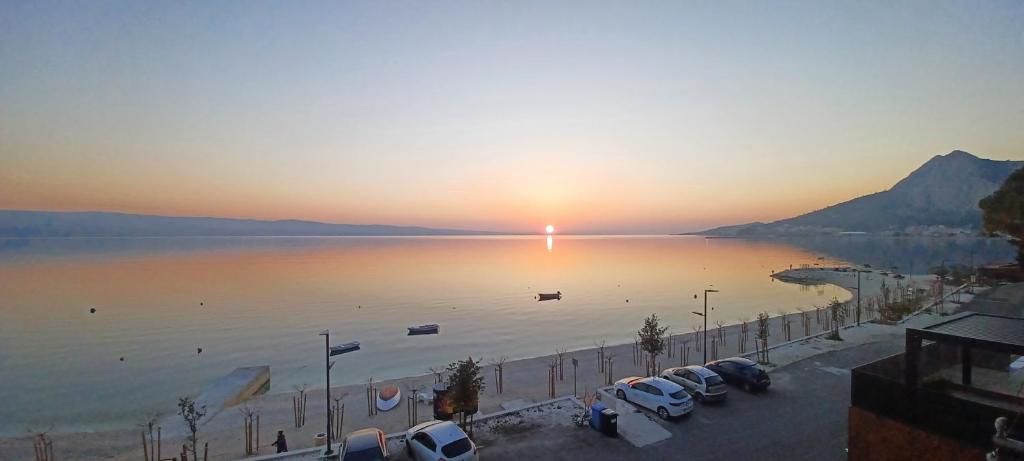 a sunset over a body of water with parked cars at Apartman studio Babilo 1 in Omiš