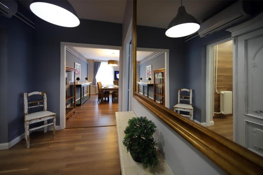 - un couloir avec un miroir, une table et des chaises dans l'établissement Rádi Apartman, à Eger