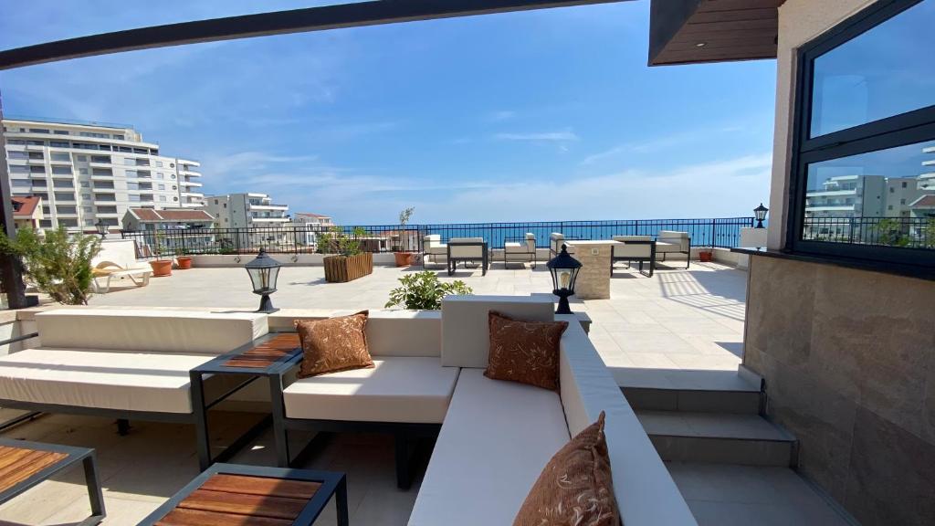 Un balcón con sofás y vistas al océano. en Adriatic Apartments, en Ulcinj