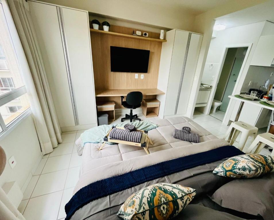 a bedroom with a large bed with pillows on it at Flat 912 Super Aconchegante! in Ribeirão Preto
