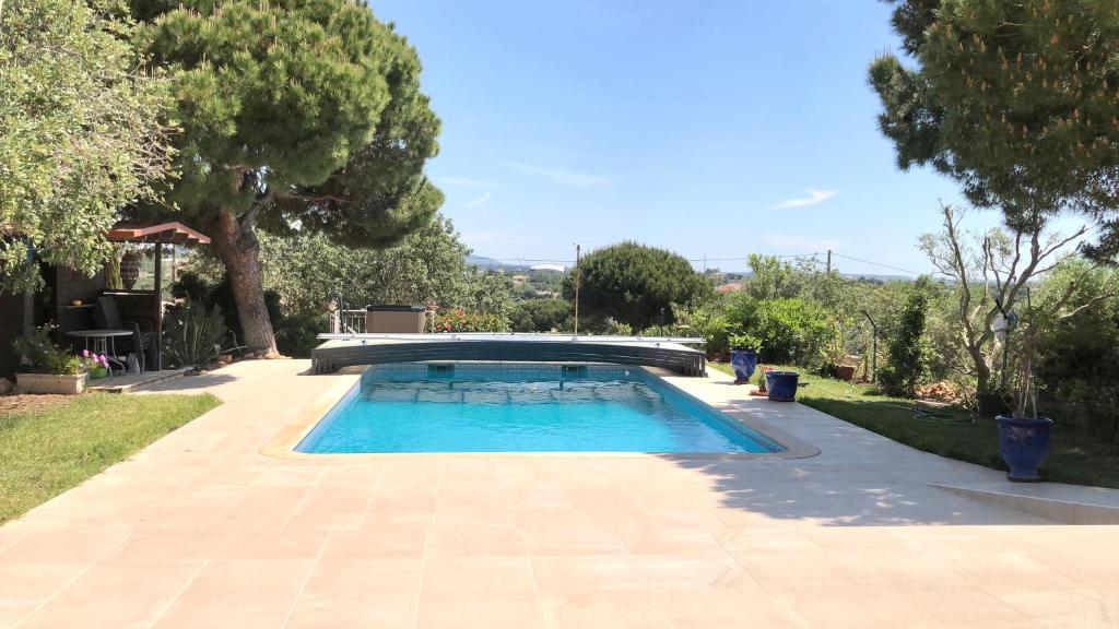 a swimming pool in a yard with trees at Fado in Almancil