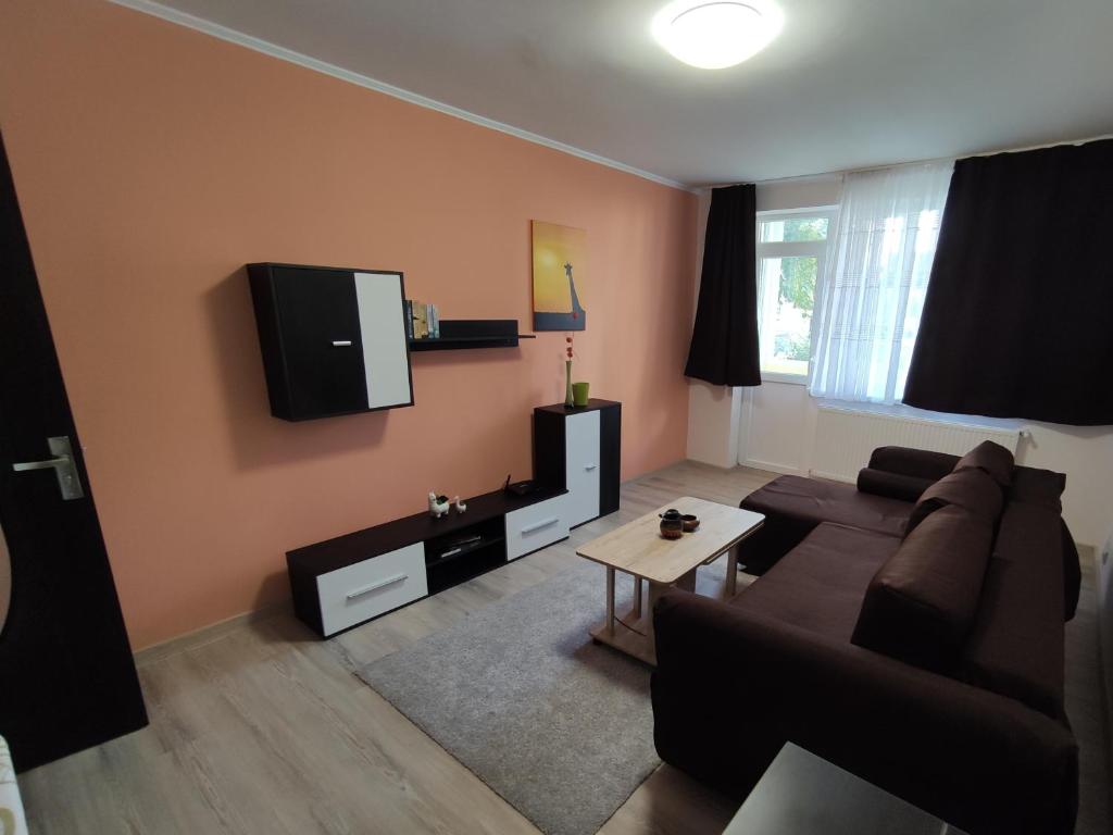 a living room with a couch and a tv on the wall at Zoldrebi apartment in Turda