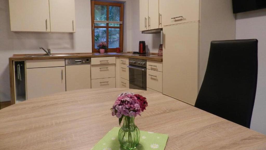 eine Blumenvase auf einem Tisch in einer Küche in der Unterkunft Ferienwohnung Jung in Hohenburg