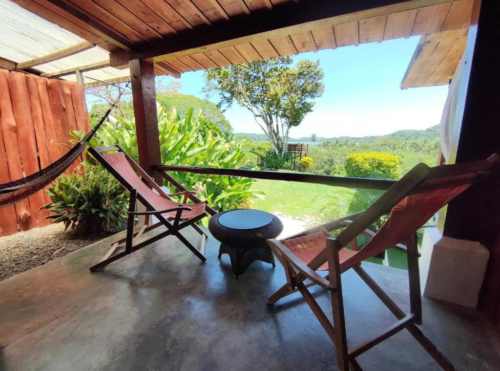 twee stoelen en een tafel op een veranda met uitzicht bij La Puesta del Sol B&B in Carrillo