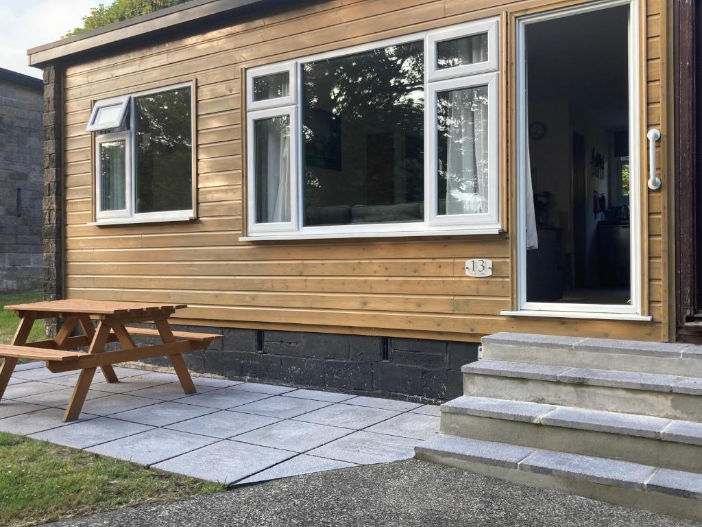 a wooden house with a picnic table outside of it at 13 The Park in Kilkhampton