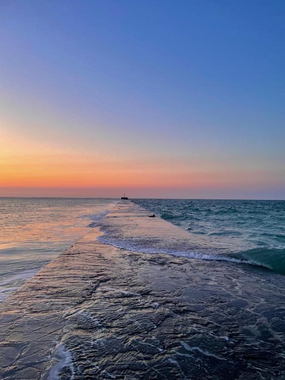 a long pier in the ocean at sunset at Sur le chemin de la plage in Cherbourg en Cotentin