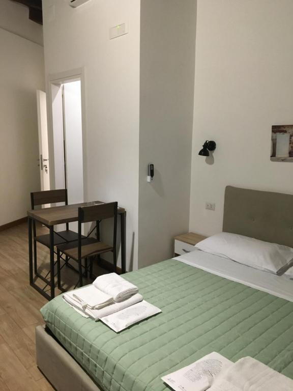 ein Schlafzimmer mit einem Bett und einem Tisch mit Handtüchern darauf in der Unterkunft Largo Otranto - Guest House in Brindisi