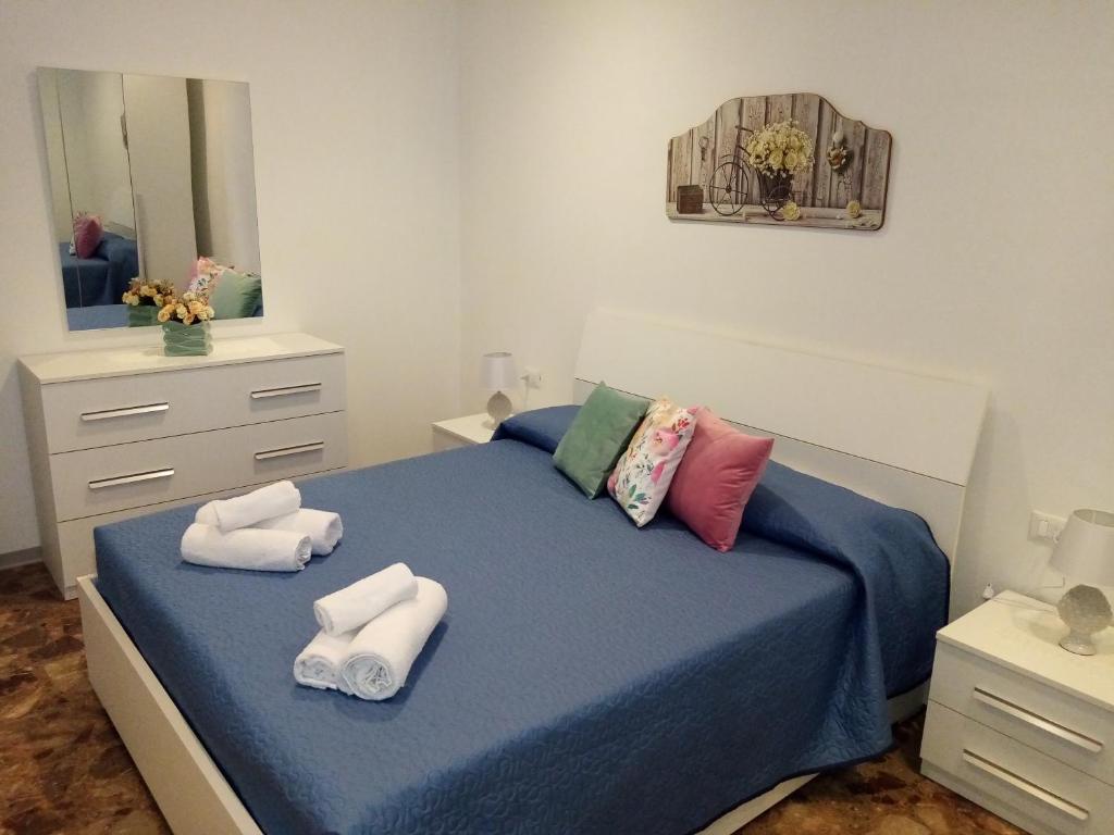 ein Schlafzimmer mit einem blauen Bett und Handtüchern darauf in der Unterkunft Eva Casa Vacanza in Felline