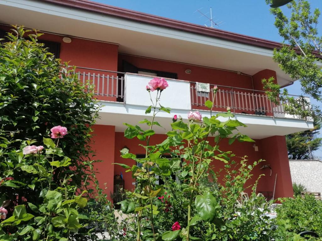 een rood huis met een balkon en bloemen bij Villa Montemma in Montesarchio