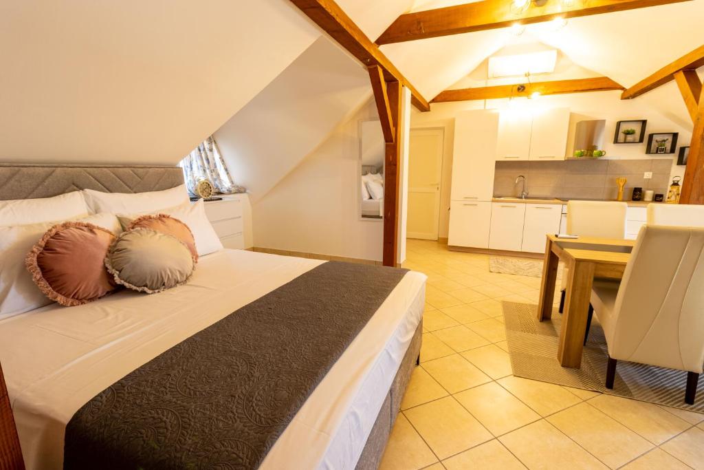 a bedroom with a bed and a table and a kitchen at STYLISH STUDIO APARTMENT BURE in Murter