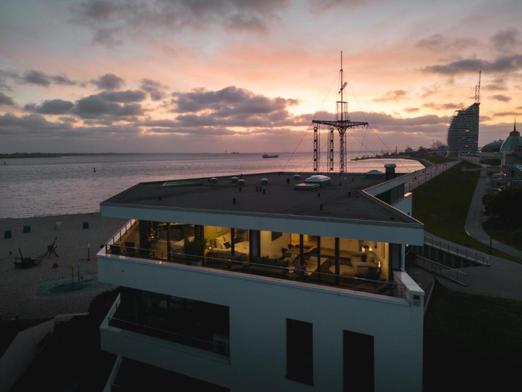 a building with a view of the ocean and a sunset at Bheaven I Marina Premium Apartment in Bremerhaven