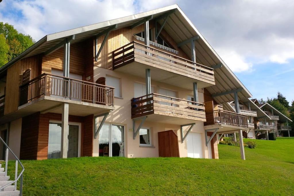 a house with balconies on the side of it at Appartement dans Chalet, vue Lac, terrasse in Gérardmer
