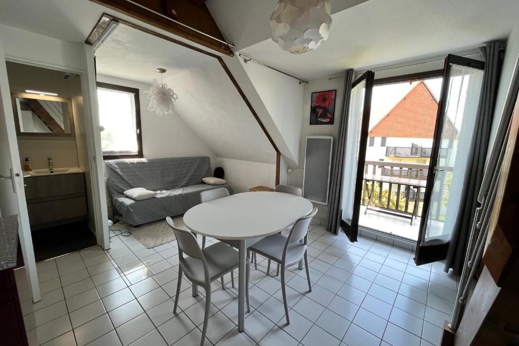 une cuisine et un salon avec une table et des chaises dans l'établissement Charming cocoon, à Cabourg