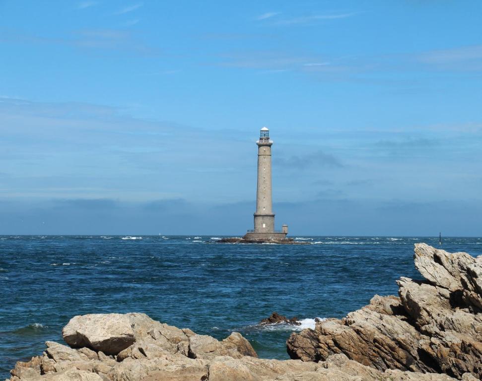 a lighthouse on an island in the water at Sur le chemin de la plage in Cherbourg en Cotentin