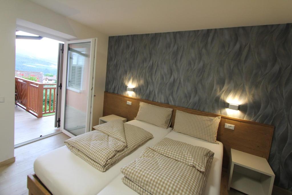 1 dormitorio con 1 cama y 2 sillas y balcón en AFFITTACAMERE B&B MERCEDES, en Romallo