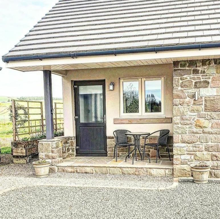 a stone house with a table and chairs on a porch at The Wee Stay - Room Only - Rural 1 Bed Guest Suite in Middleton Fossoway