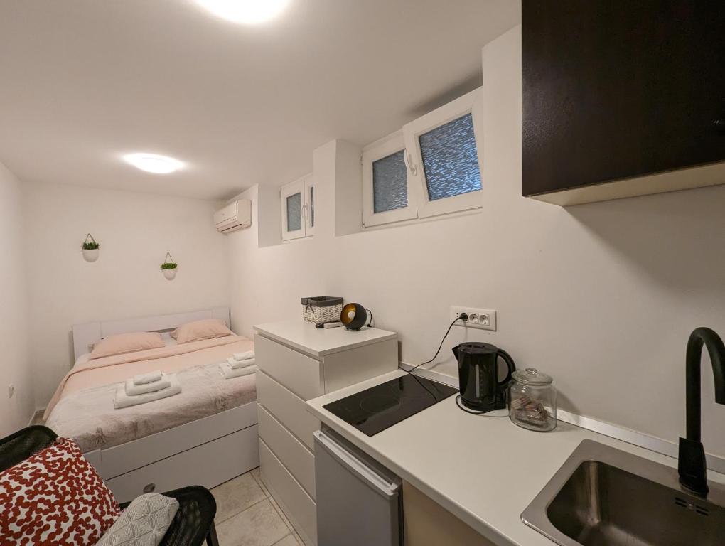 małą kuchnię z łóżkiem w małym pokoju w obiekcie Petite Studio With Ensuite Bathroom w Zagrzebiu