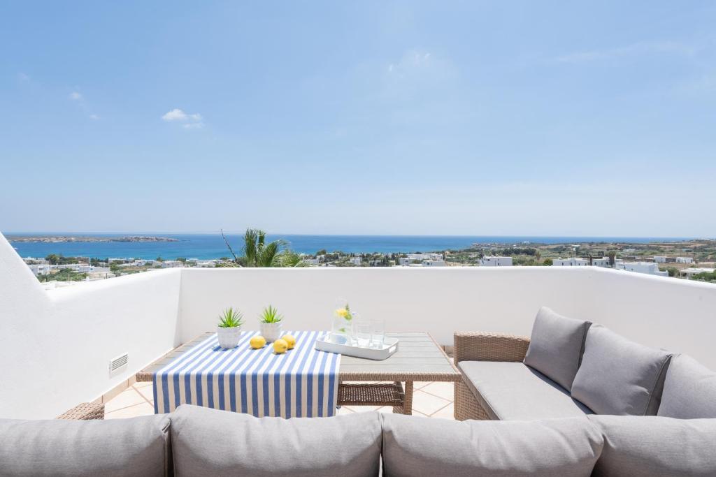 een patio met een tafel en stoelen op een balkon bij Sealit Deluxe Apartment in Drios