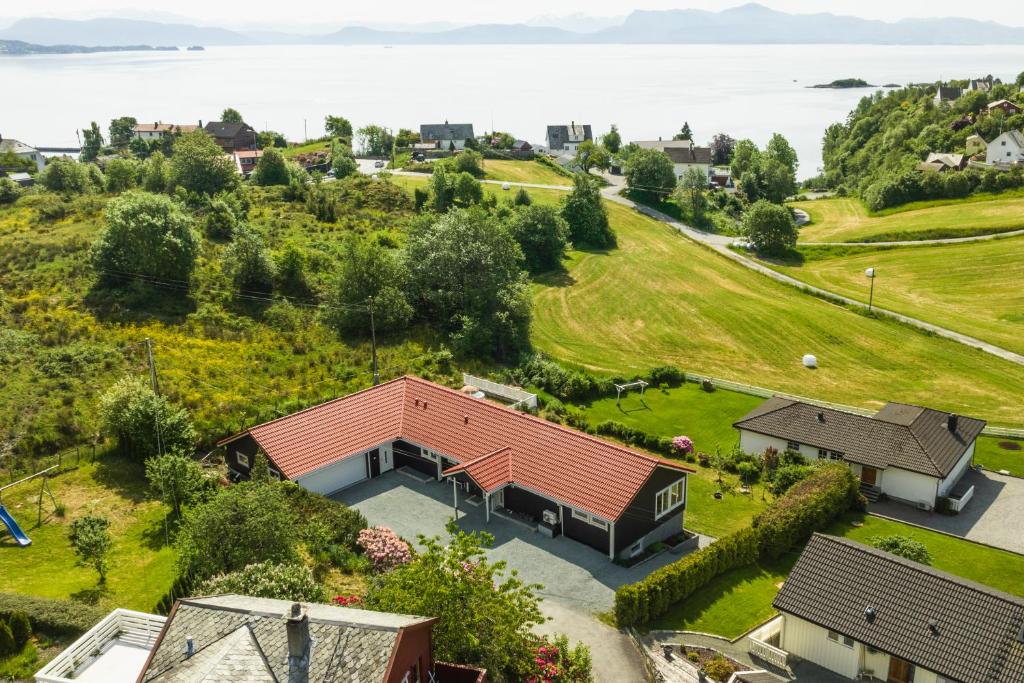 Villa i Bjørnafjorden في Osøyro: اطلالة جوية على منزل بسقف احمر