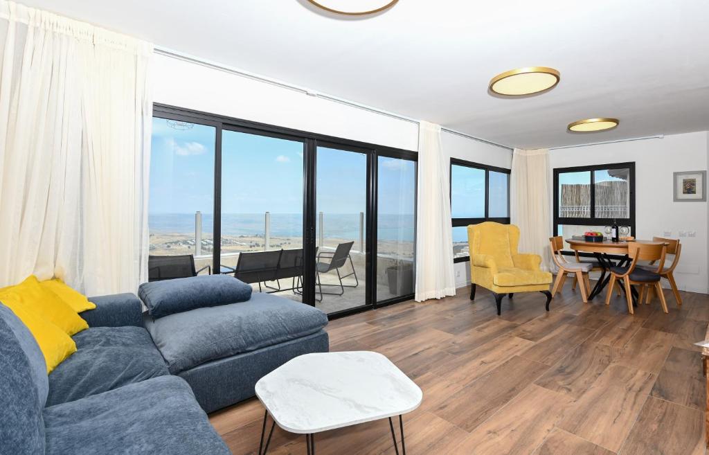 a living room with a couch and a table with chairs at נוף העמק - דירה מהממת עם נוף עוצר נשימה in Nof Kinneret