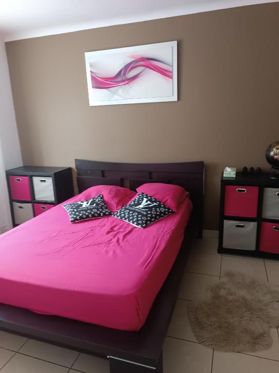 un lit rose avec deux nœuds papillon dessus dans l'établissement Nid côte bleue, à Carry-le-Rouet