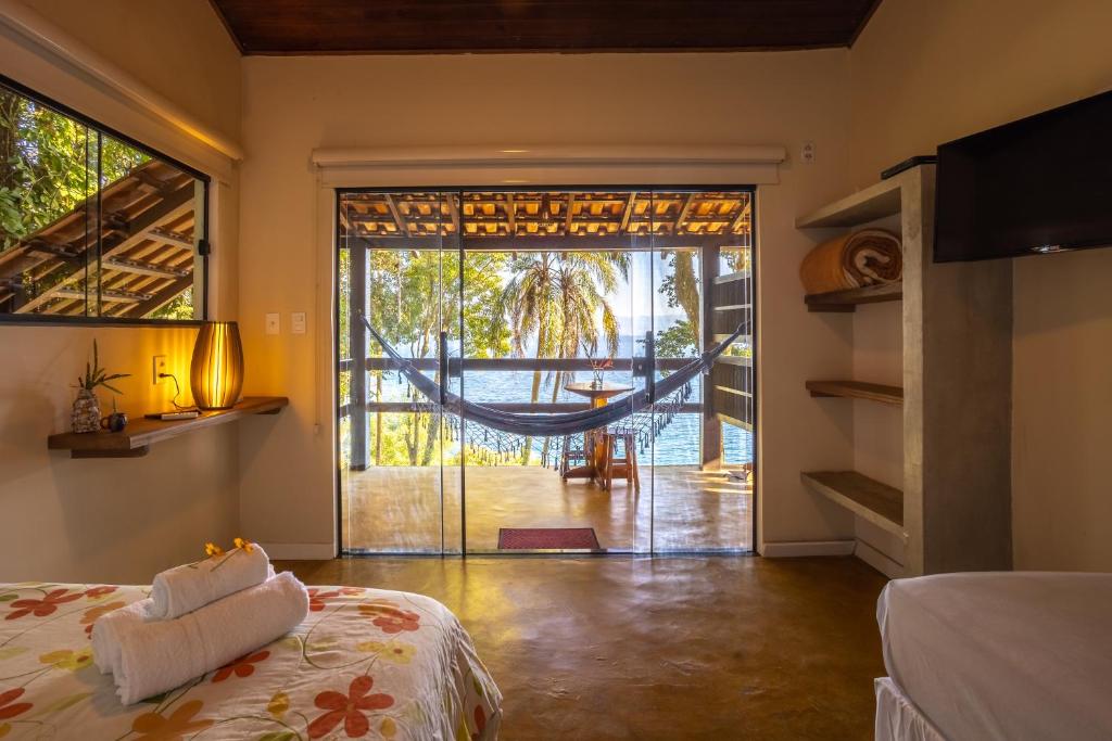 a room with a bed and a hammock in it at Pousada Lagamar in Praia Vermelha