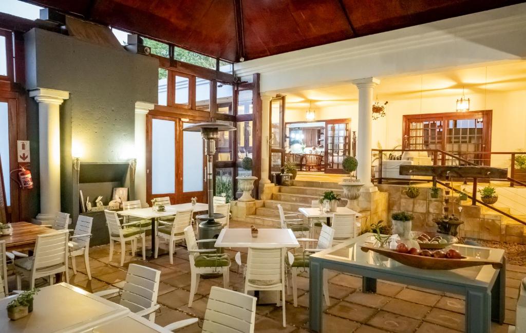 - un restaurant avec des tables et des chaises dans une salle dans l'établissement Spacube Luxury Suites and Spa, à Pretoria