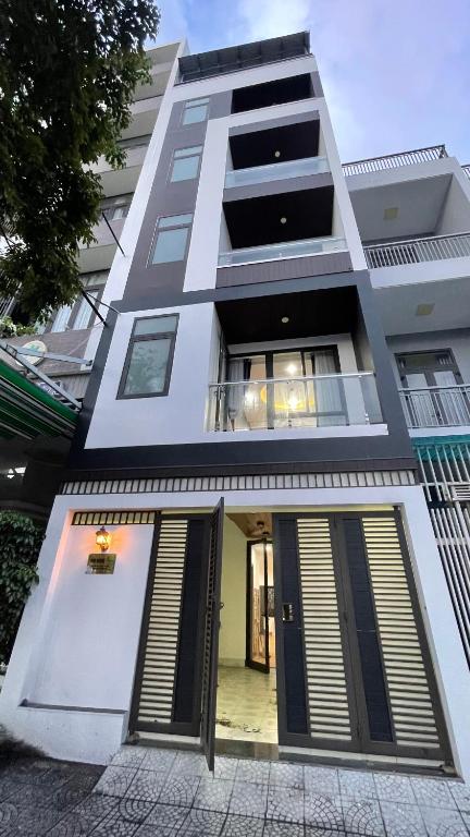 a tall white building with its doors open at Kim House Apartment Da Nang in Danang