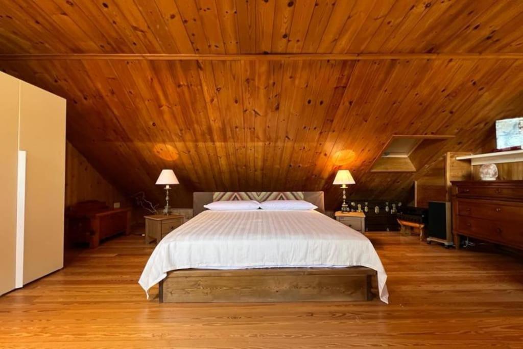 um quarto com uma cama e um tecto em madeira em L'abete, bilocale su due piani in centro storico em Sondrio