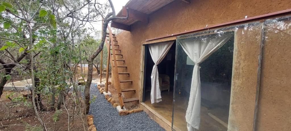 a building with a window with a ladder next to it at Hartbeest Eco Bush Lodge 3 in Hartbeespoort