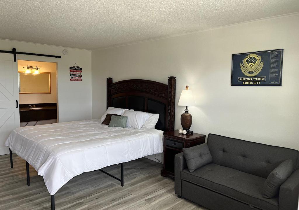 um quarto com uma cama e um sofá em Ballparks Inn em Branson