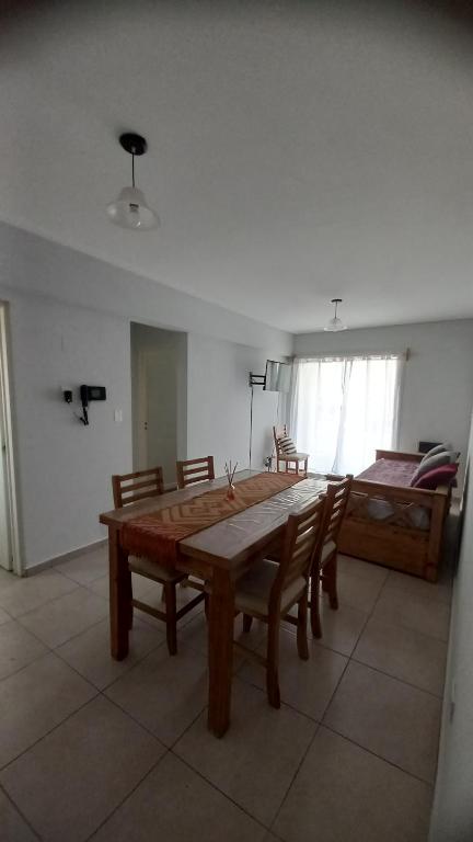 a room with a wooden table and chairs and a bed at Centro Norte lll con cochera incluida in Bahía Blanca